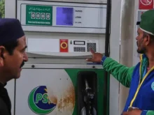 A fuel pump nozzle being used at a petrol pump station in Pakistan for vehicle refueling